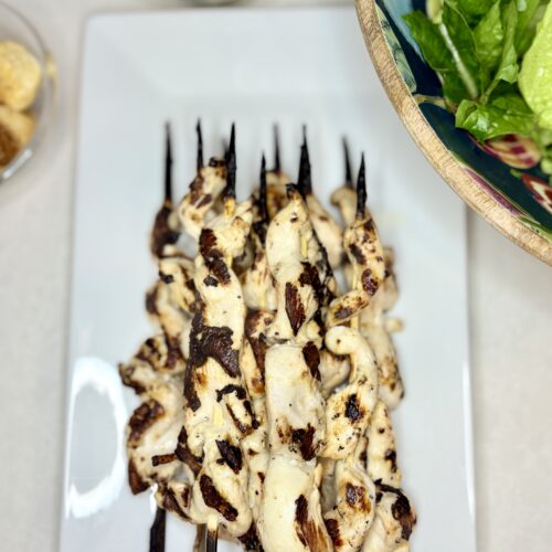 grilled chicken skewers on a plate on a counter