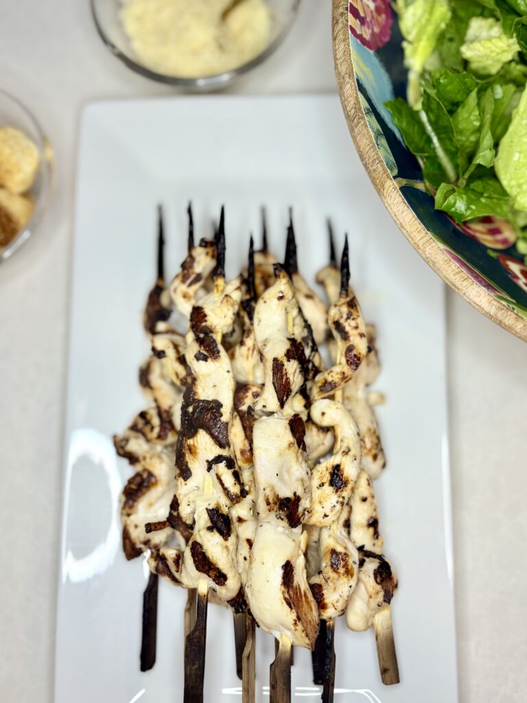 grilled chicken skewers on a plate on a counter