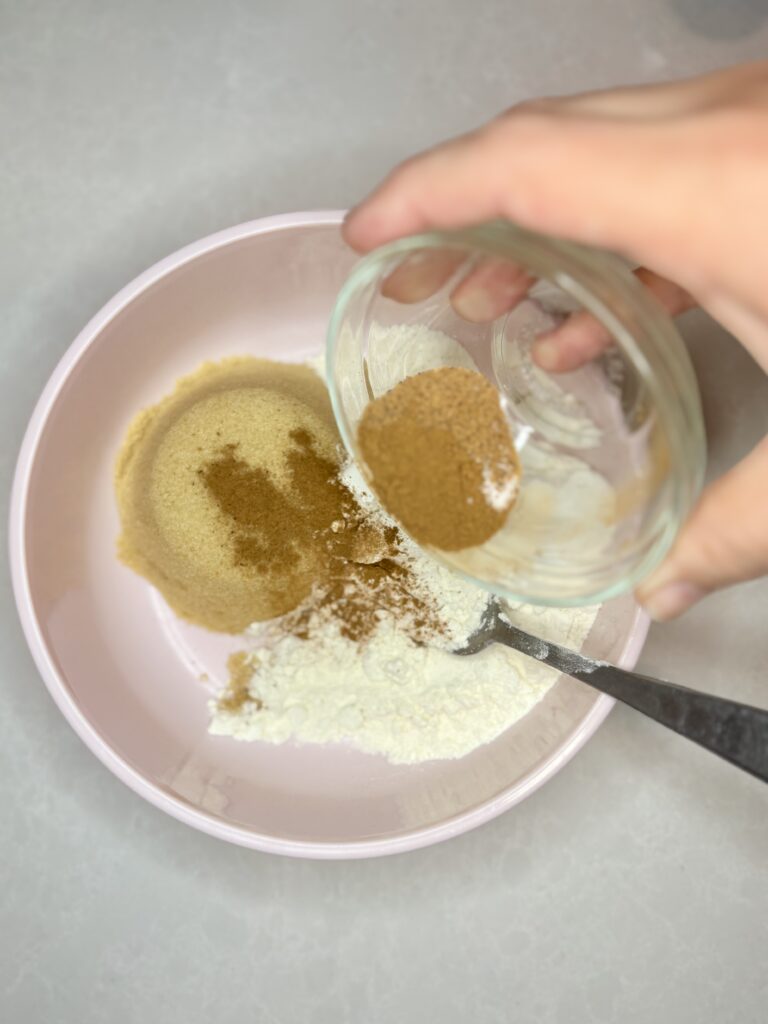 seasoning being poured into a bowl with flour and brown sugar