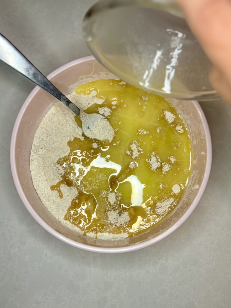 butter being poured into bowl with flour and brown sugar