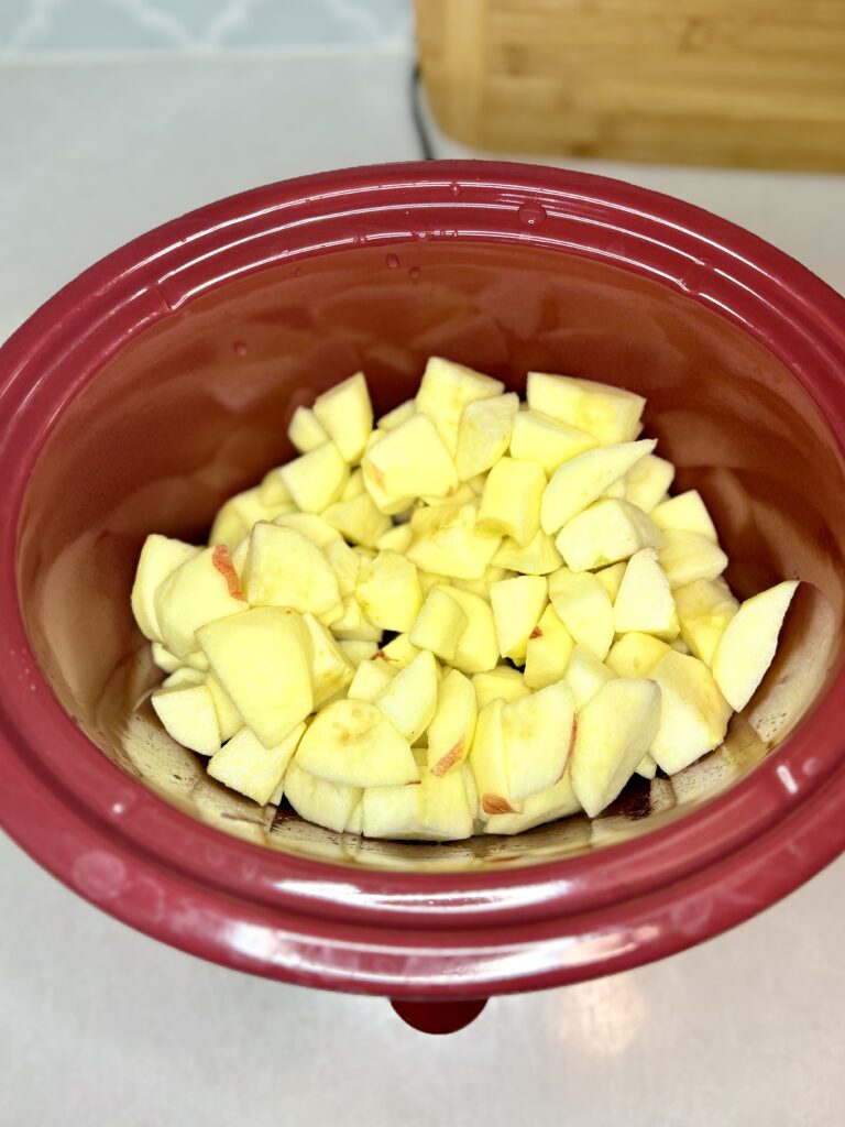 a slow cooker with cut up apples in it