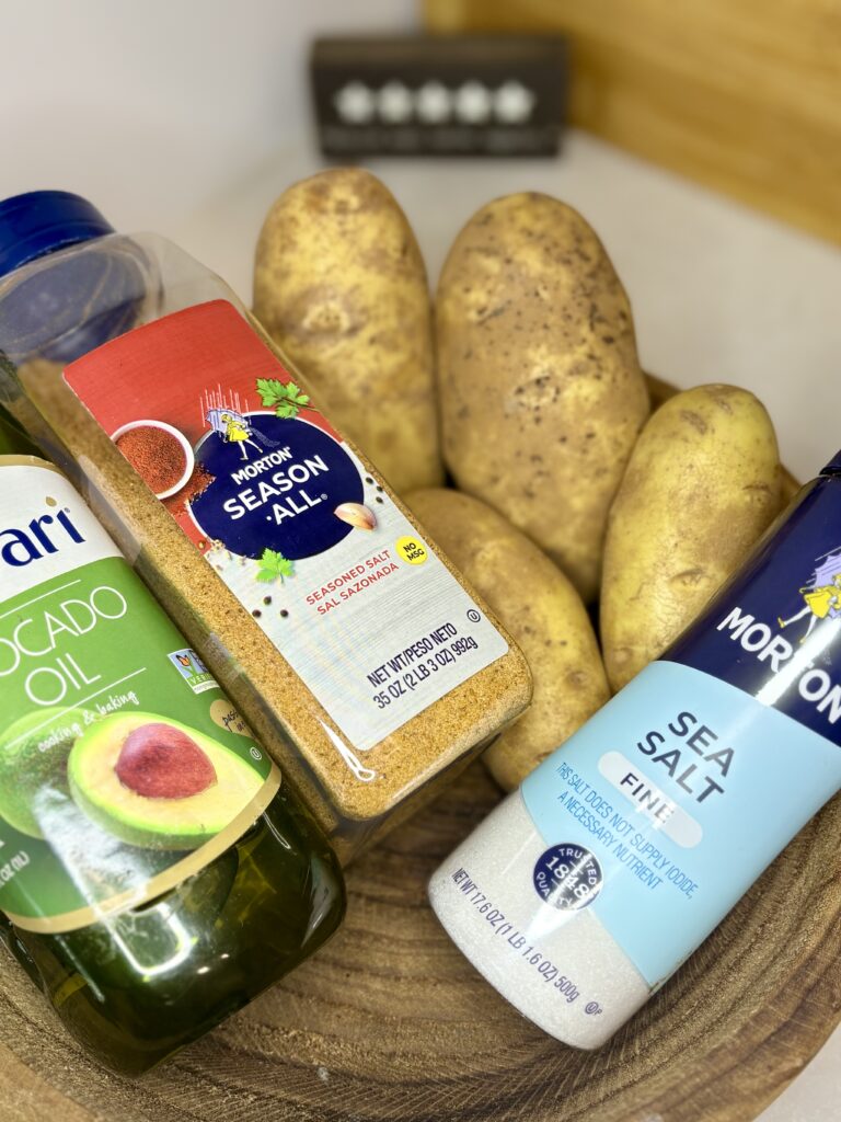 potatoes, salt, oil, and seasoned salt in a bowl on a counter