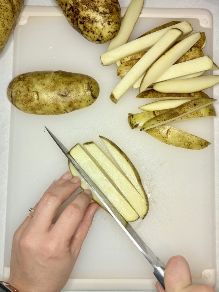 potato slices being cut into fry shapes