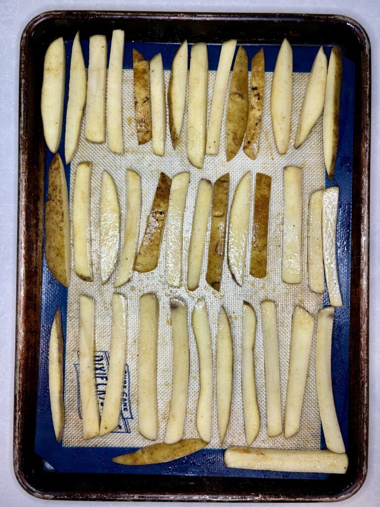 uncooked fries on a baking sheet