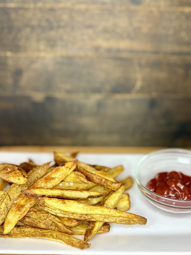 oven fries on a plate next to ketchup