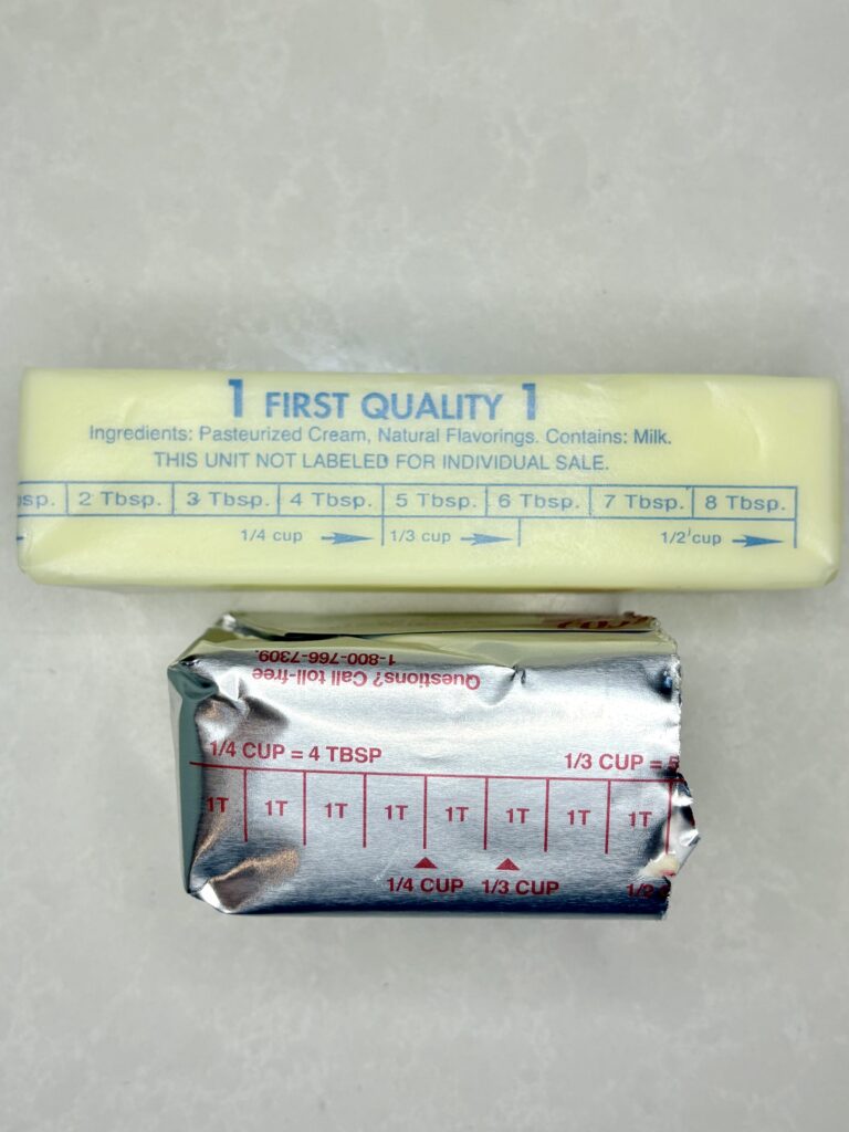 a stick of butter softening on a counter next to half a stick of shortening