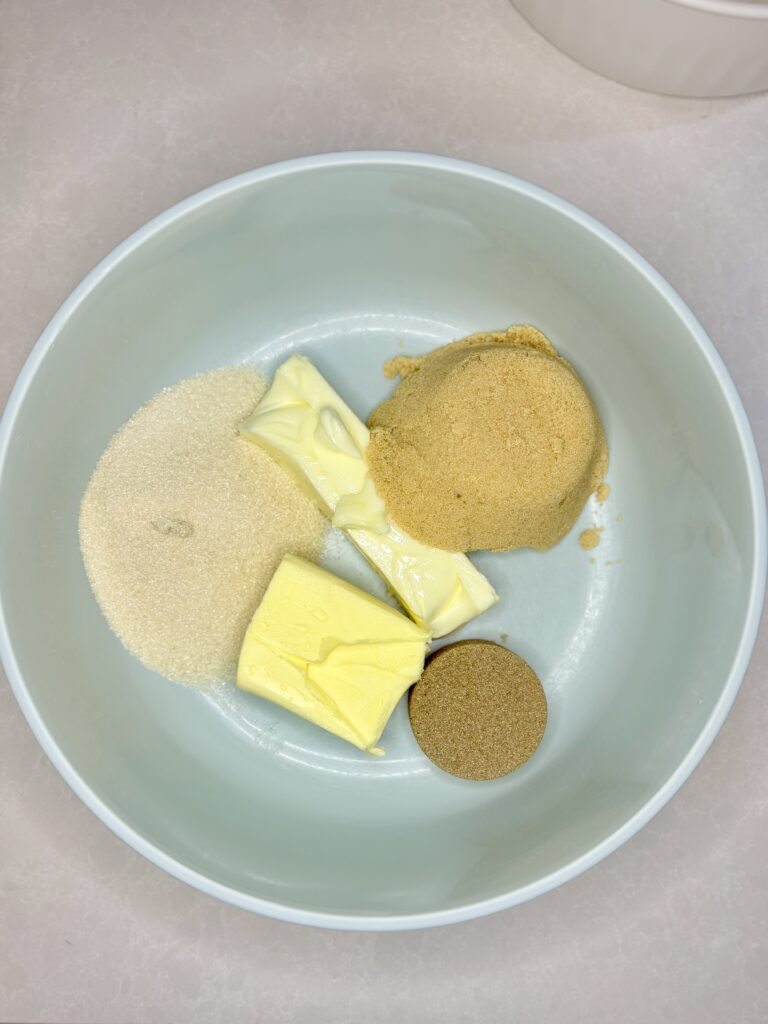 butter, shortening, sugar, light brown sugar and dark brown sugar in a bowl