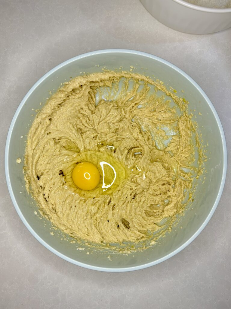 a egg cracked into a bowl of dough