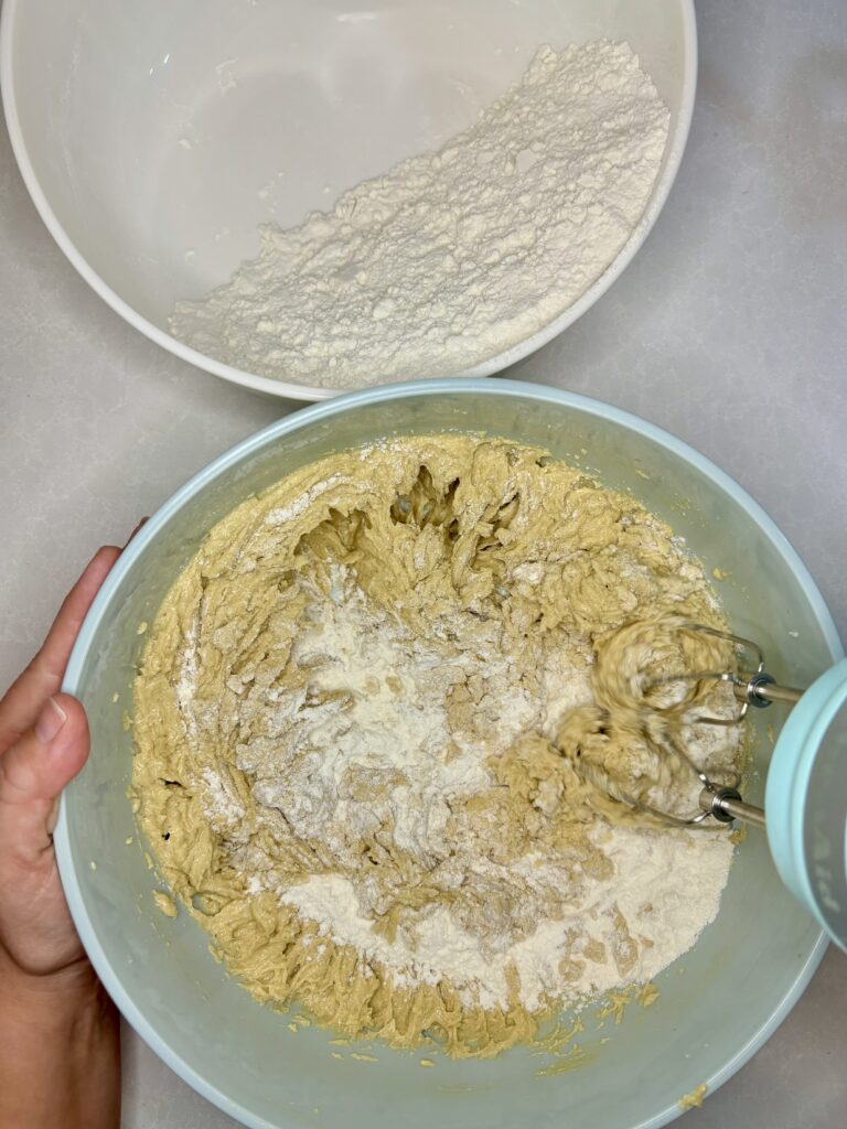 flour being mixed into dough with a hand mixer