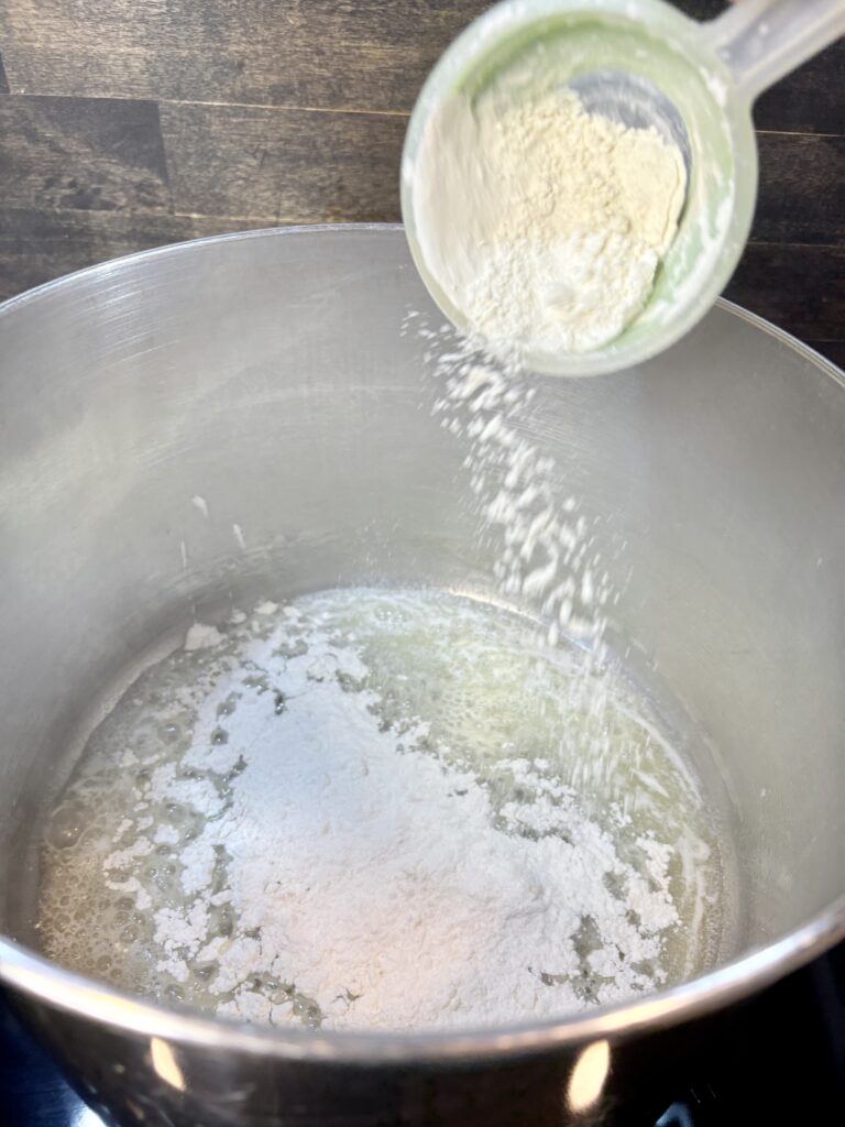 flour being added to melted butter in a large pot