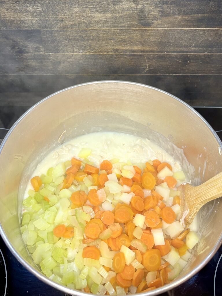 steamed vegetables being stirred into pot