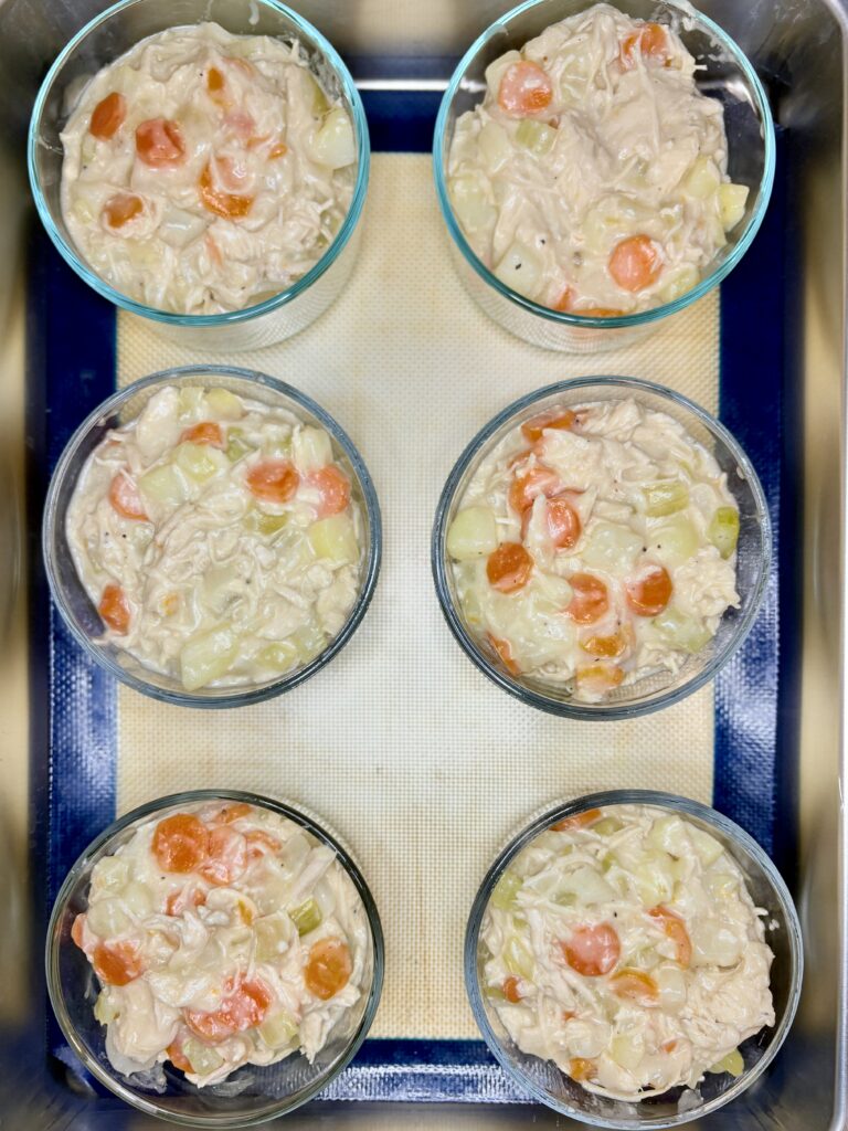 small dishes filled with chicken pot pie mixture on a baking sheet