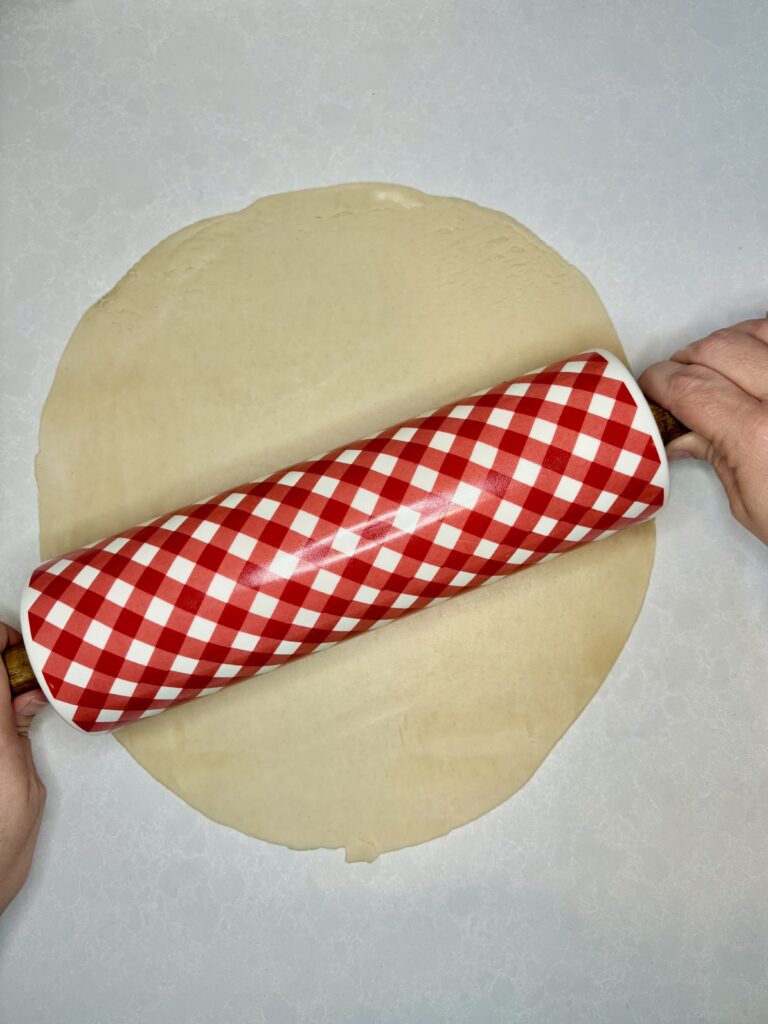 pie crust being rolled out on to a counter