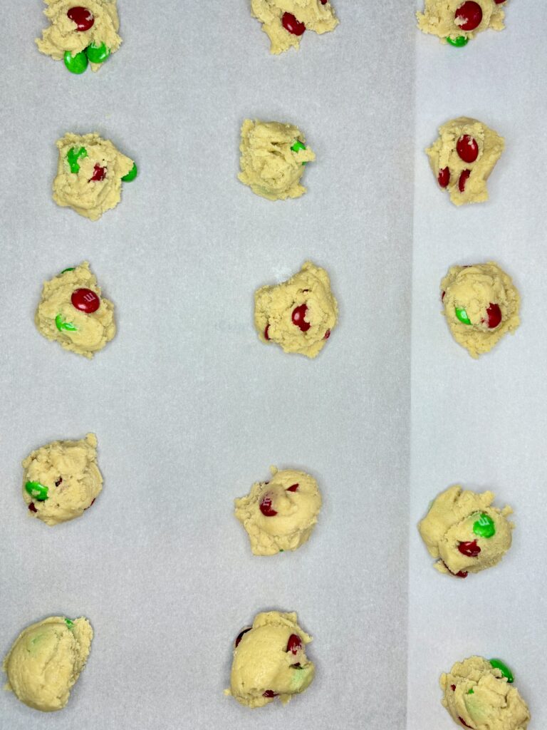 scoops of dough on a cookie sheet lined with parchment paper