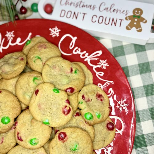 m&m cookies on a plate next to a towel on a counter