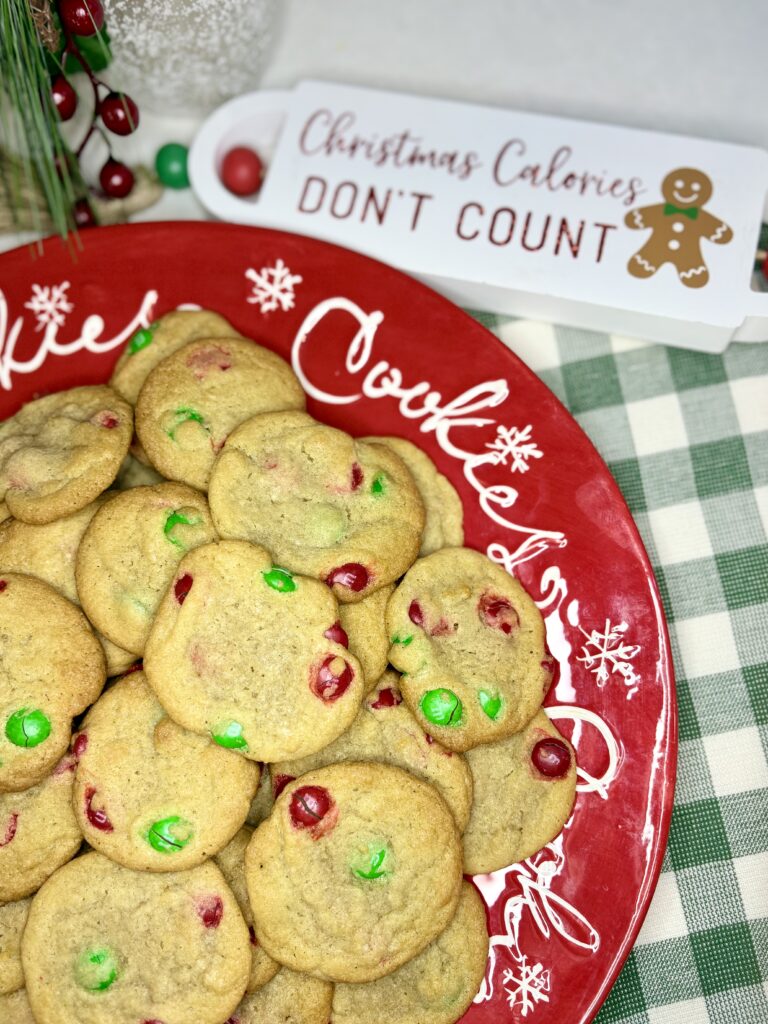 m&m cookies on a plate next to a towel on a counter