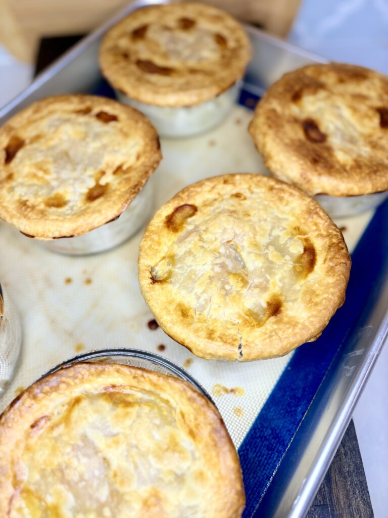 cooked chicken pot pies on a baking sheet