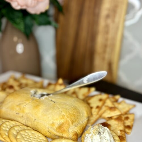 creamy dill dip on a plate with crackers on a counter