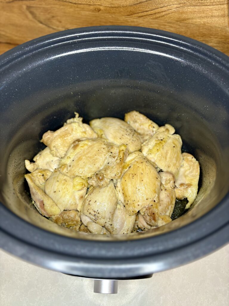 browned chicken thighs in a slow cooker