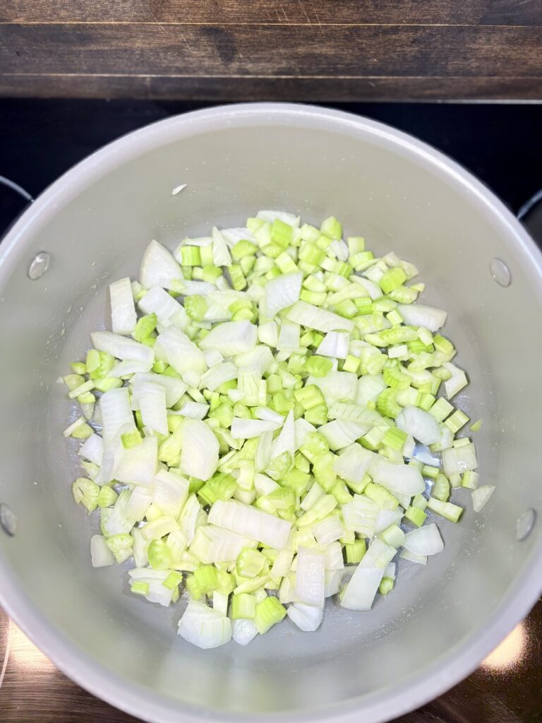 celery and onion sautéing in a pot