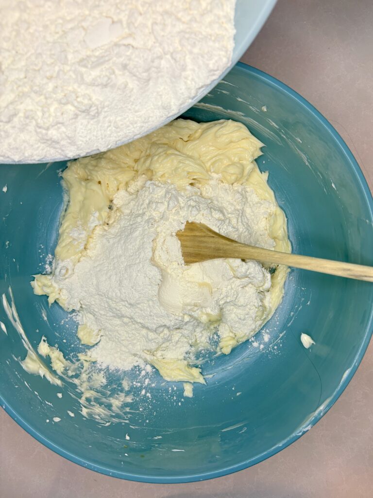 flour being added to butter sugar mixture