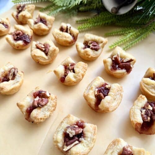 Mini puff pastry tarts with cherry filling and chopped nuts, perfect for holiday gatherings and festive desserts. Easy to make with flaky pastry, sweet cherry jam, and crunchy pecans or walnuts.