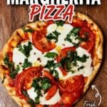 Fresh homemade Margherita pizza with tomatoes, mozzarella, basil, and a crispy crust on a wooden surface.