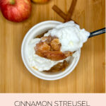 Cinnamon Streusel Apples with whipped cream in a bowl next to apples