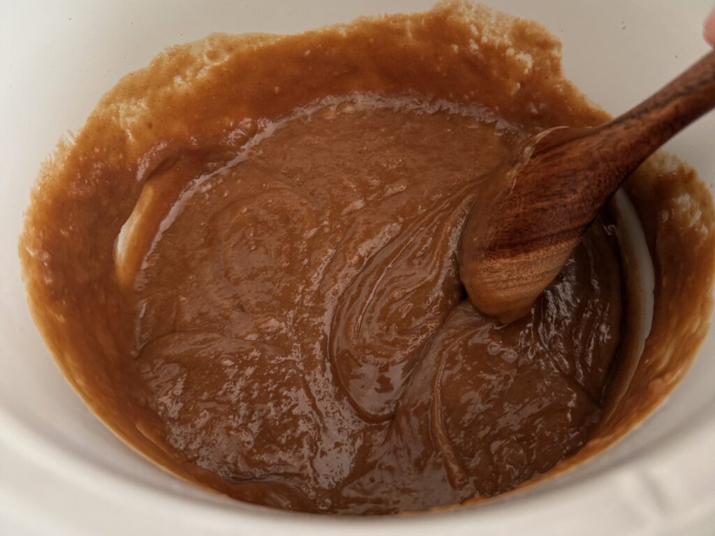 Mixing the dip in the slow cooker with a wooden spoon.