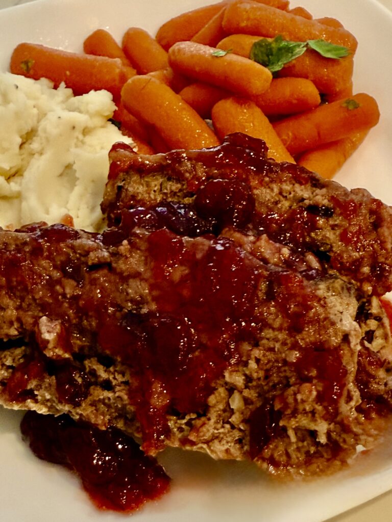 Very Merry Meatloaf with mashed potatoes and carrots on a white plate.