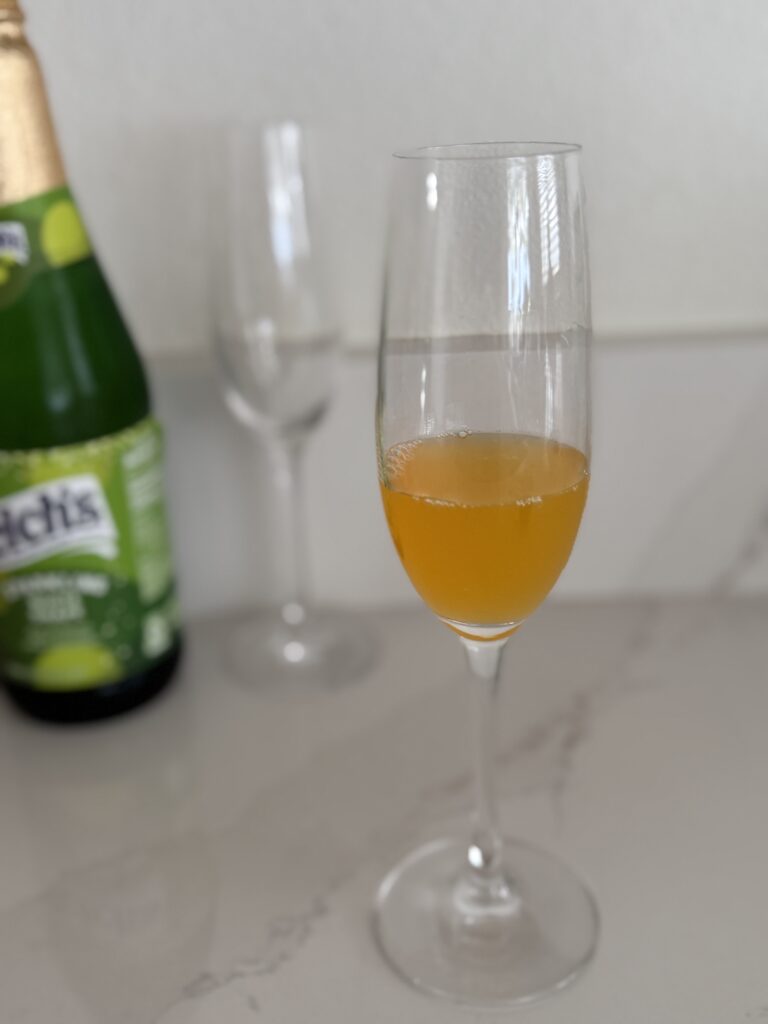 passion fruit juice in a champagne flute on the counter. 