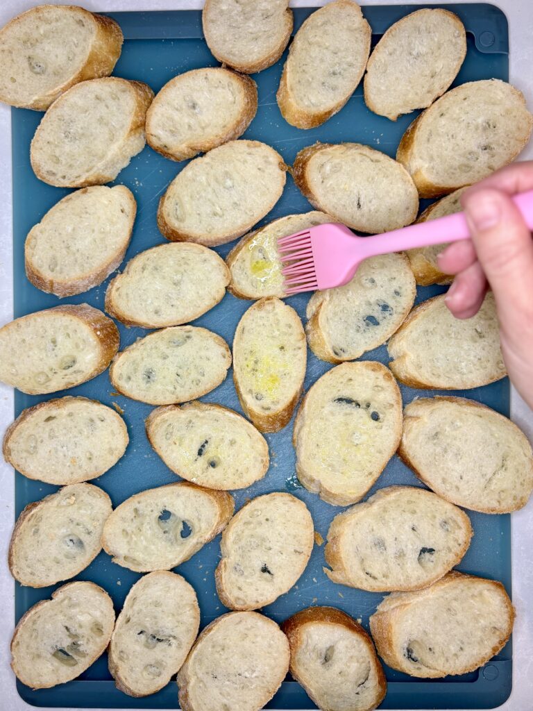 olive oil being brushed onto bread slices