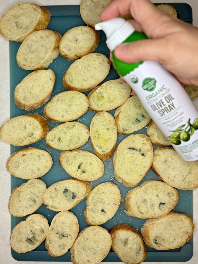 olive oil being sprayed on to bread slices