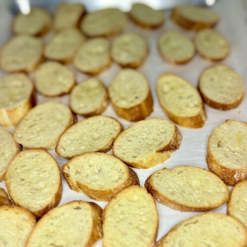 toasted crostinis on a baking sheet