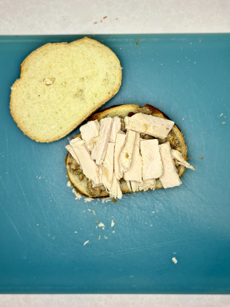 a slice of bread with stuffing and turkey on it on a cutting board 