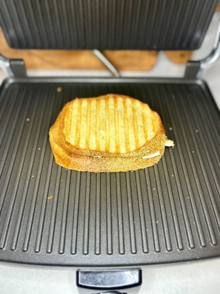 a cooked turkey panini on a panini press. 