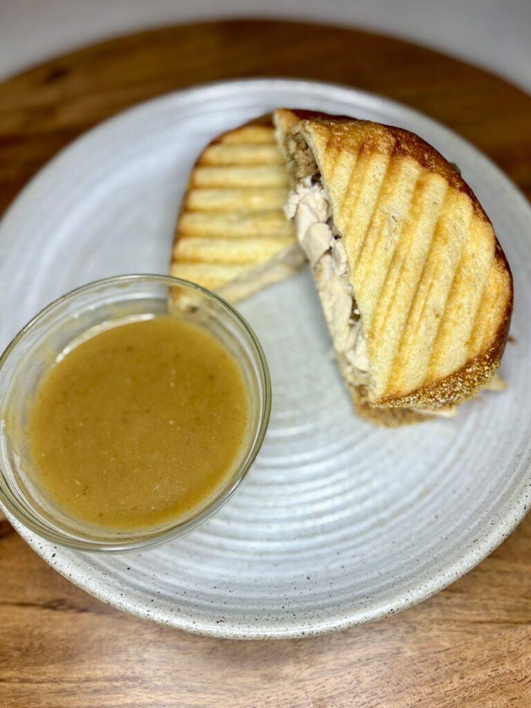 a pressed sandwich on a plate with gravy