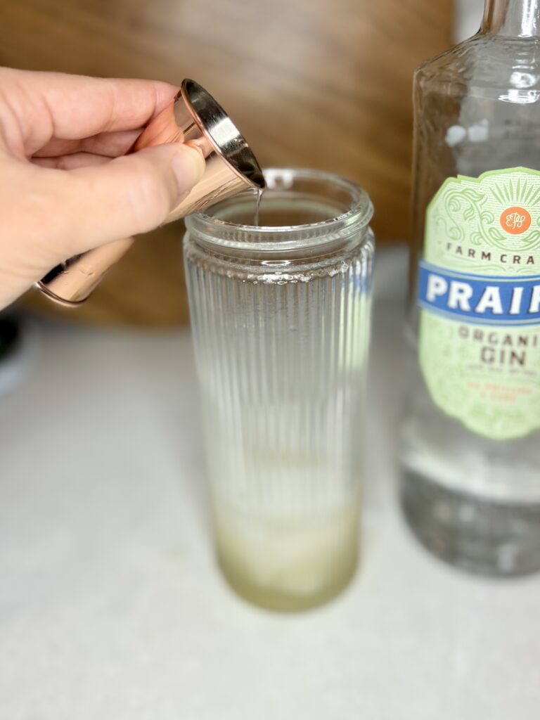 gin being poured in to cocktail shaker