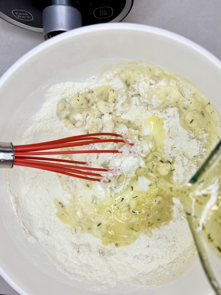 broth from slow cooker being whisked in to a bowl of flour 