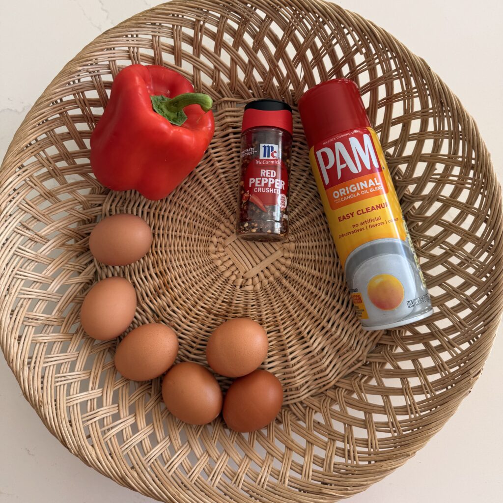 fresh red pepper, red pepper flakes, non stick spray and 6 eggs in a basket on the counter.