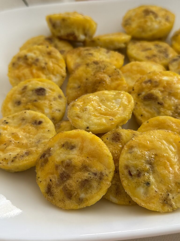 baked mini egg bites on a white plate on the counter.