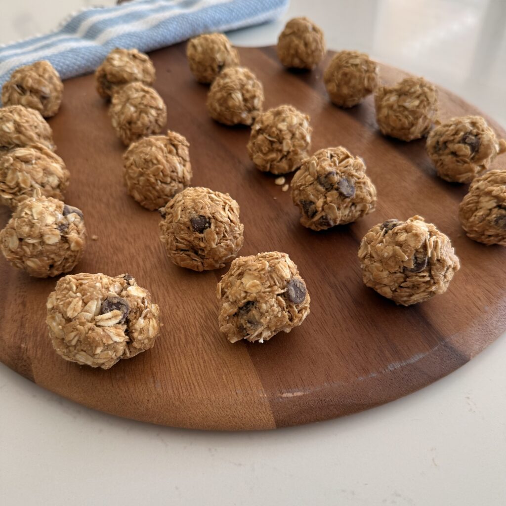 No Bake energy Bites on a brown round board on the counter.