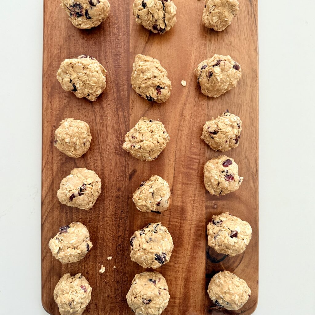 Yummy Oatmeal cranberry bites lined up on a brown cutting board on the counter.