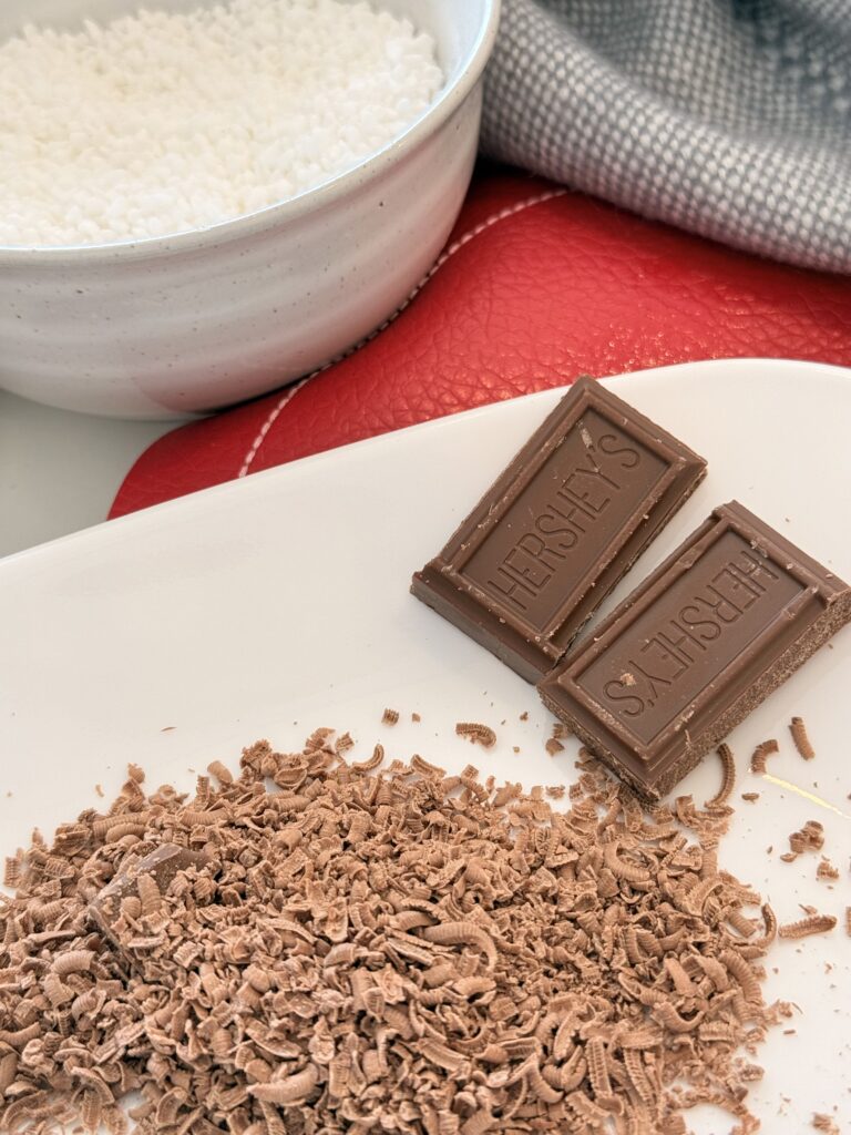 Grated chocolate on a white plate on the counter.