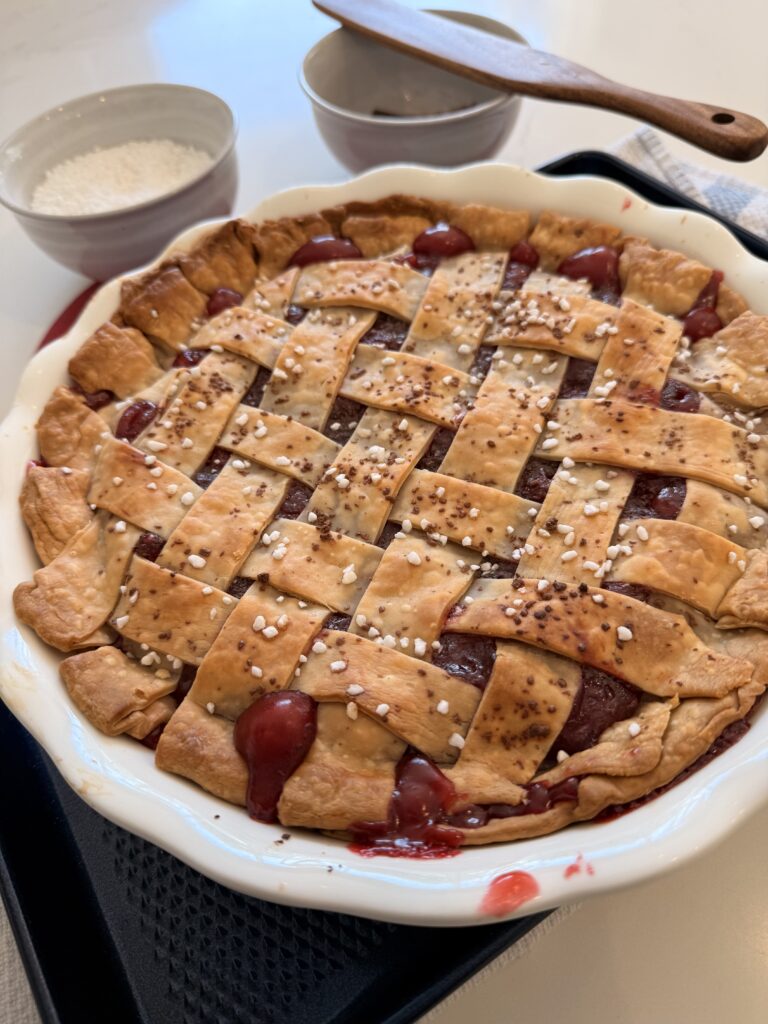 Baked Chocolate Cherry pie on a dark blue sheet pan on the counter.