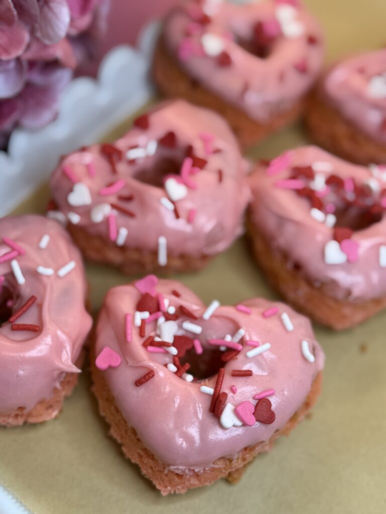 Lovestruck cake donuts on parchment paper on the counter.