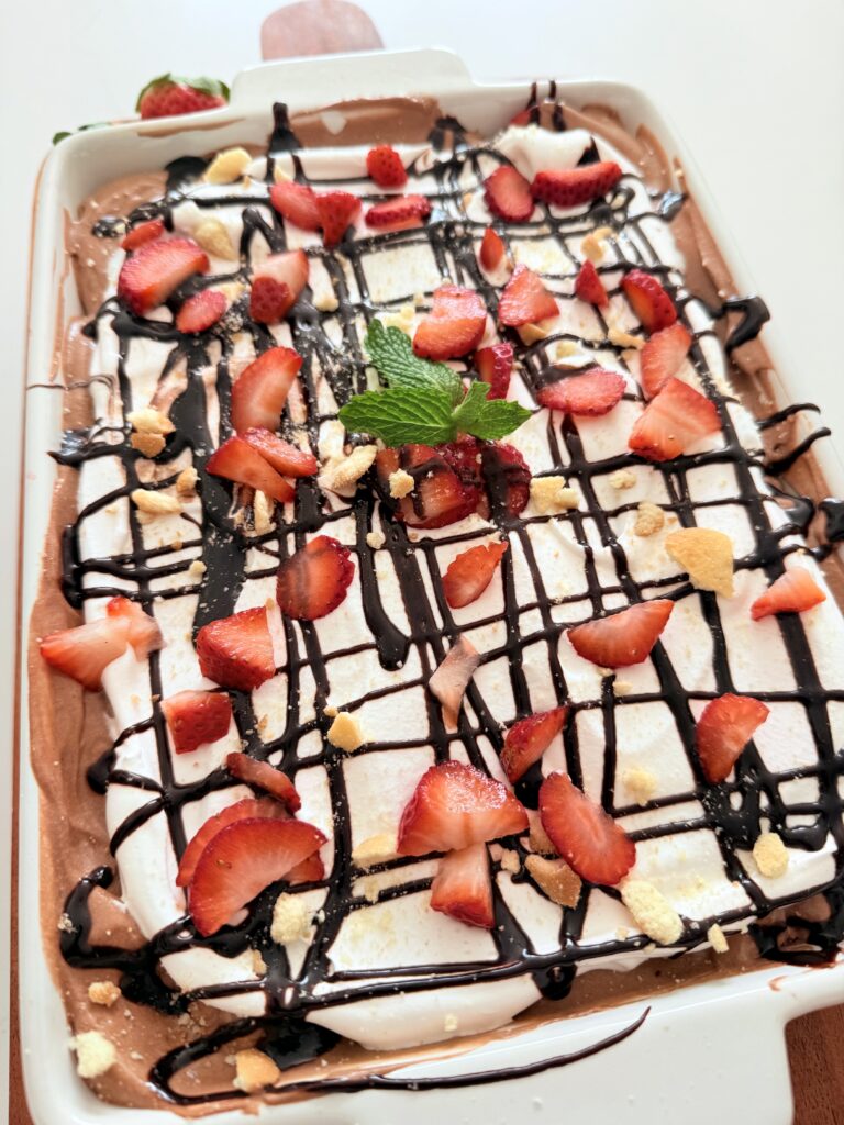  No baked strawberry chocolate dessert is on the counter in a white baking dish.