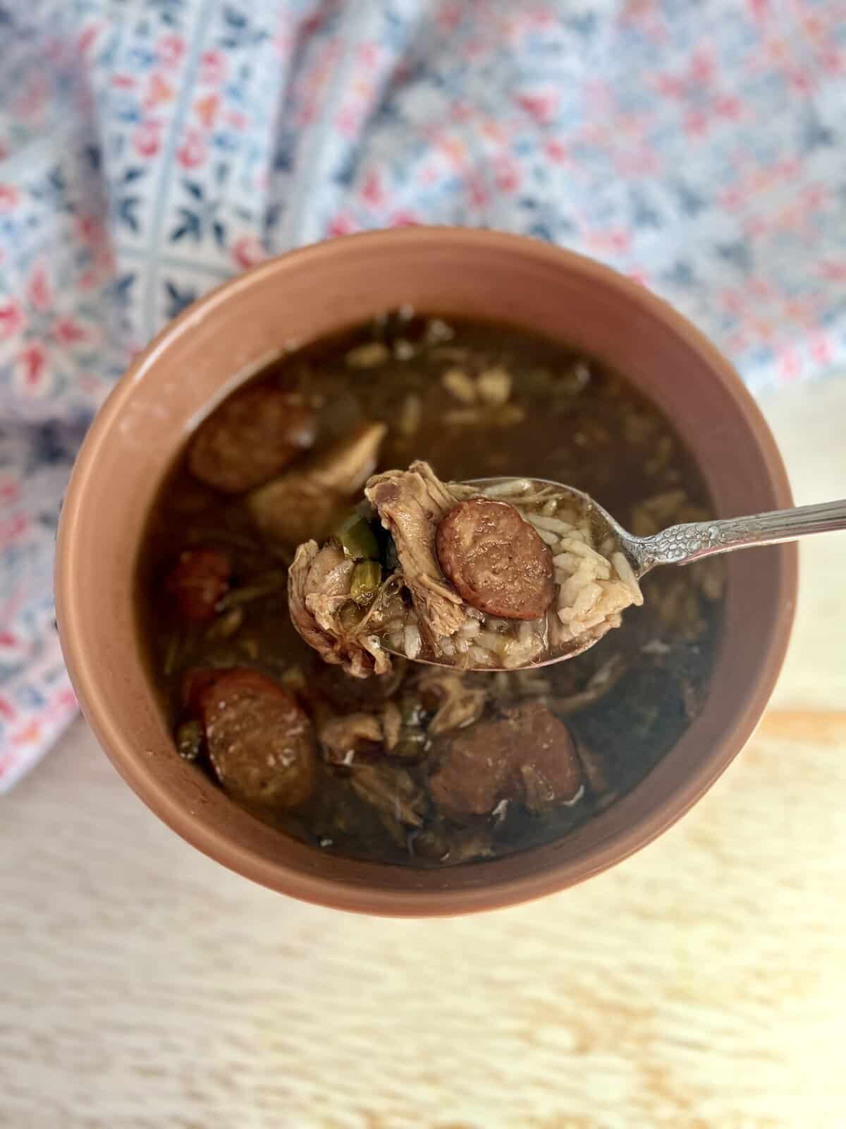 Tender beef stew with sausage and vegetables in a savory broth, served in a rustic clay bowl, perfect for comforting homemade meals and family dinners.