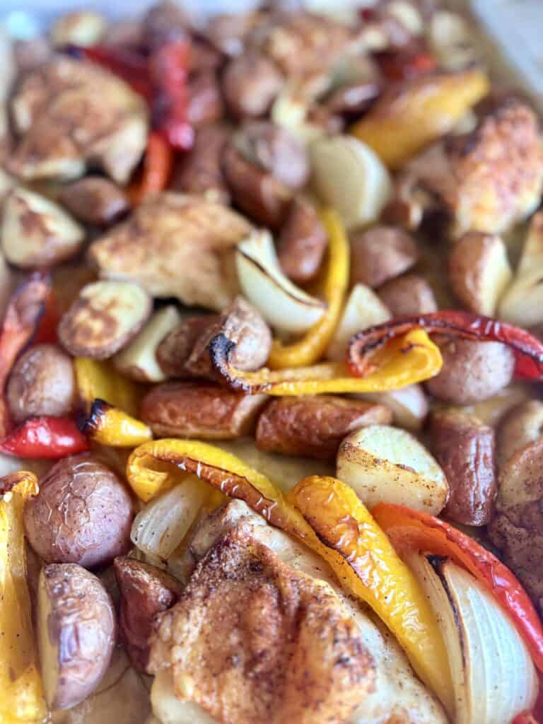 Delicious chicken and andouille sausage sheet pan dinner with colorful peppers and onions, perfect for easy weeknight meals and flavorful Southern-inspired cuisine.