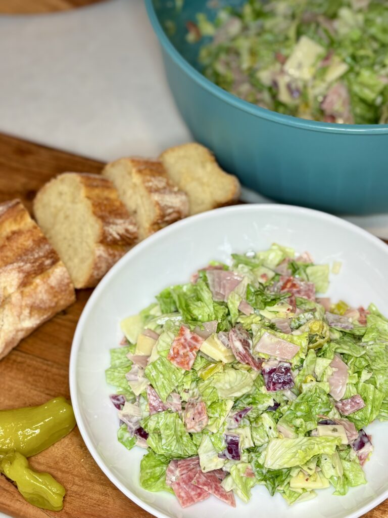 chopped antipasto salad in a meal bowl next to sliced bread